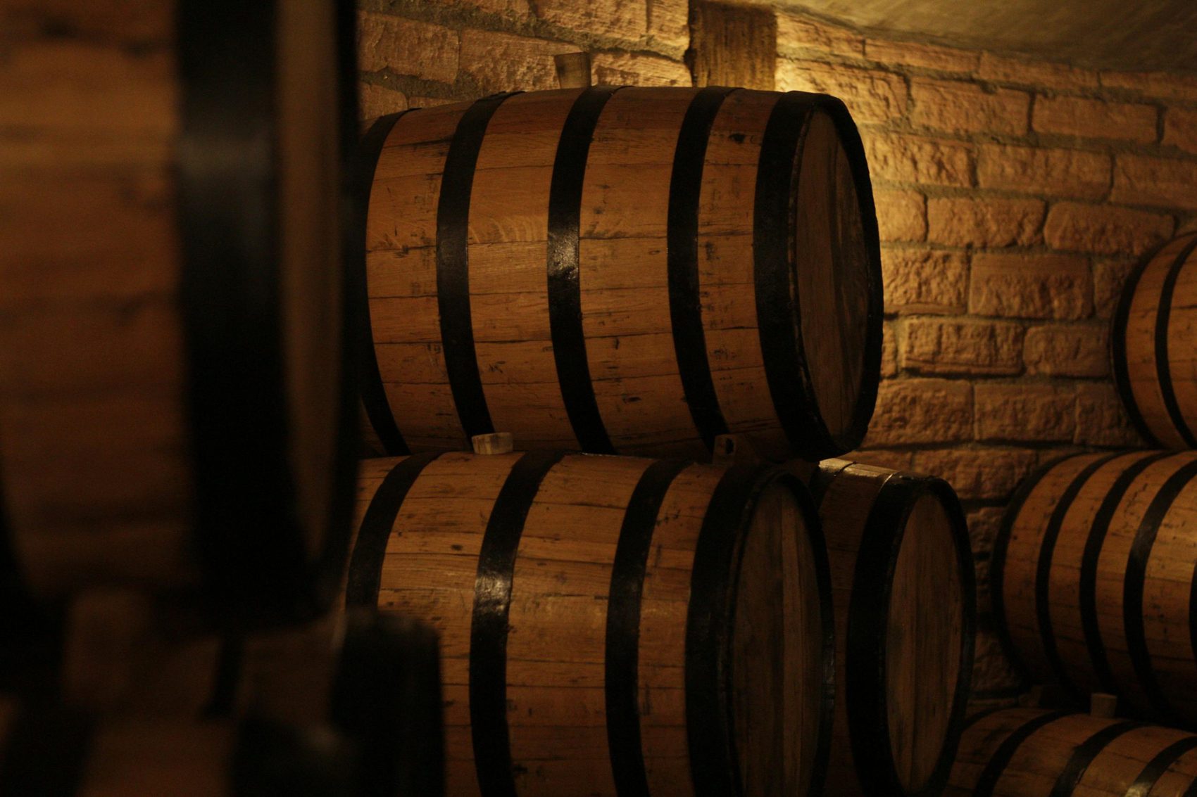 Barricas de roble apiladas en la bodega de añejamiento